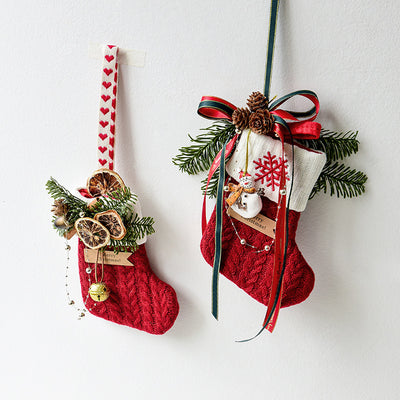 Two red Christmas stockings with decorative elements on a white background